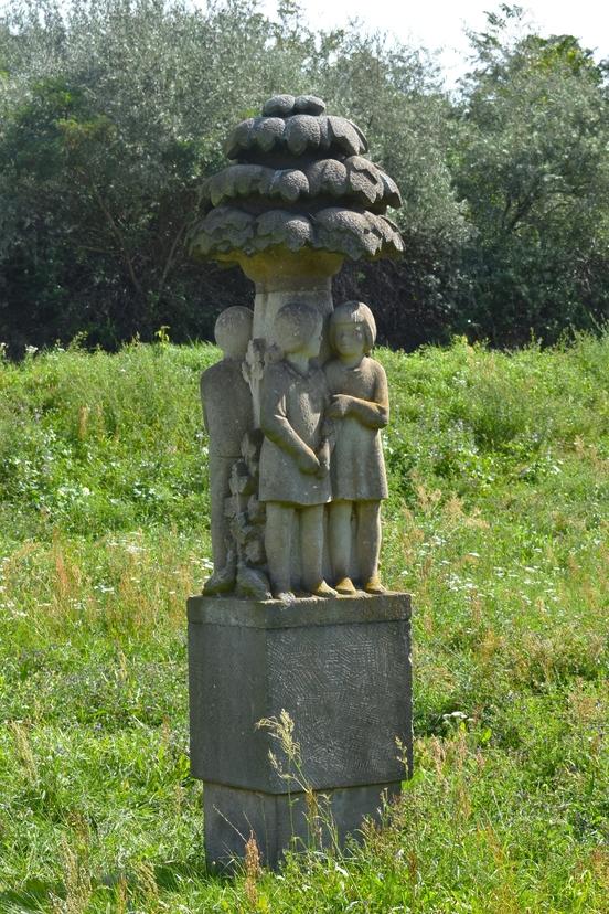 Foto der Steinskulptur, stehend auf der Wiese.