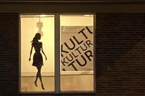 Foto einer ins Fenster geklebten Damensilhouette.