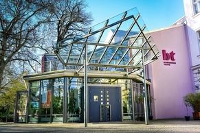 Das Theater von außen, Fokus auf das Glasvordach am Haupteingang.
