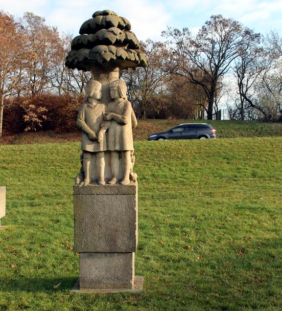 Foto der Steinskulptur auf der Wiese stehend.