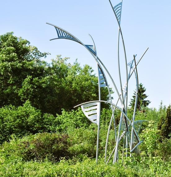 Foto der Skulptur umgeben von Grün.