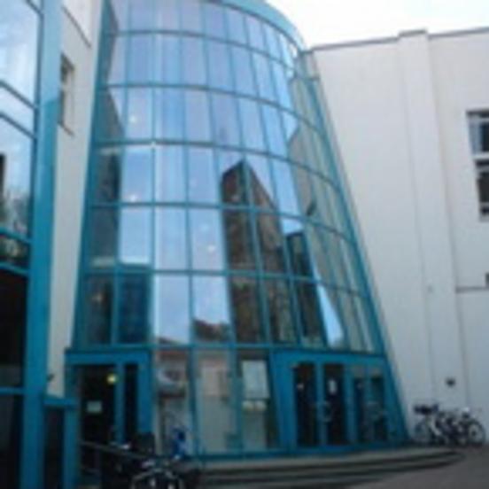 Foto der großen geneigten Glasfassade des Cinemotion Kinos in der Neustadt.